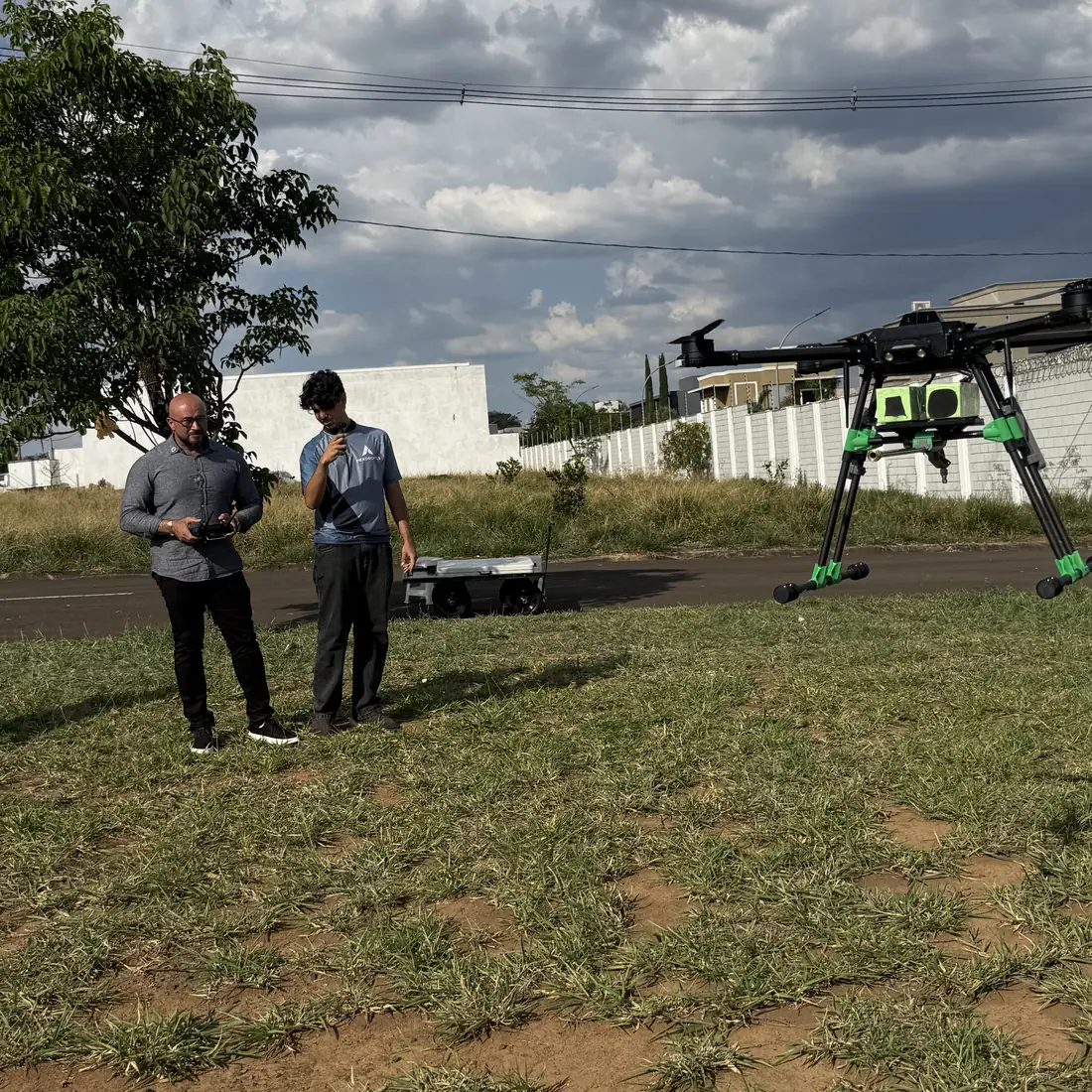 NexUAV em voo baixo durante a entrega técnica, com a equipe ao controle